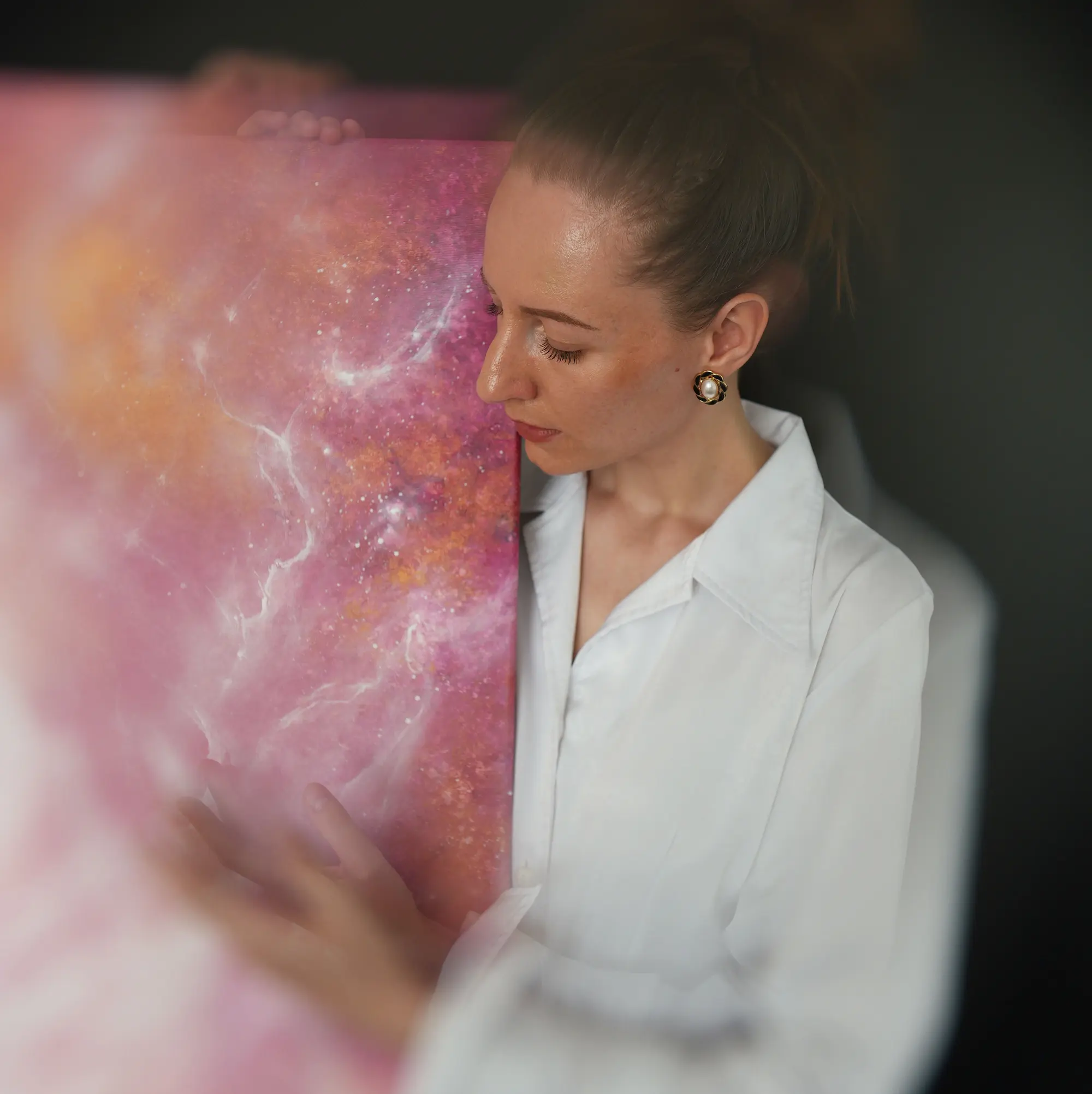 Anna Tempírová ve svém ateliéru vedle růžového abstraktního obrazu